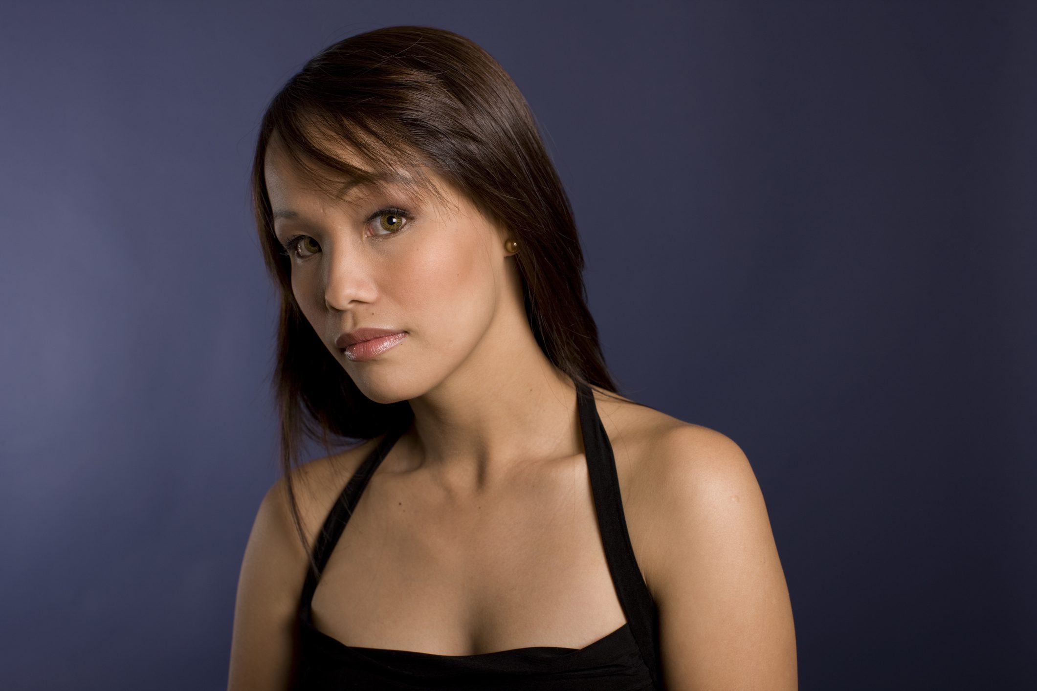 Young woman with dark hair, blue background.