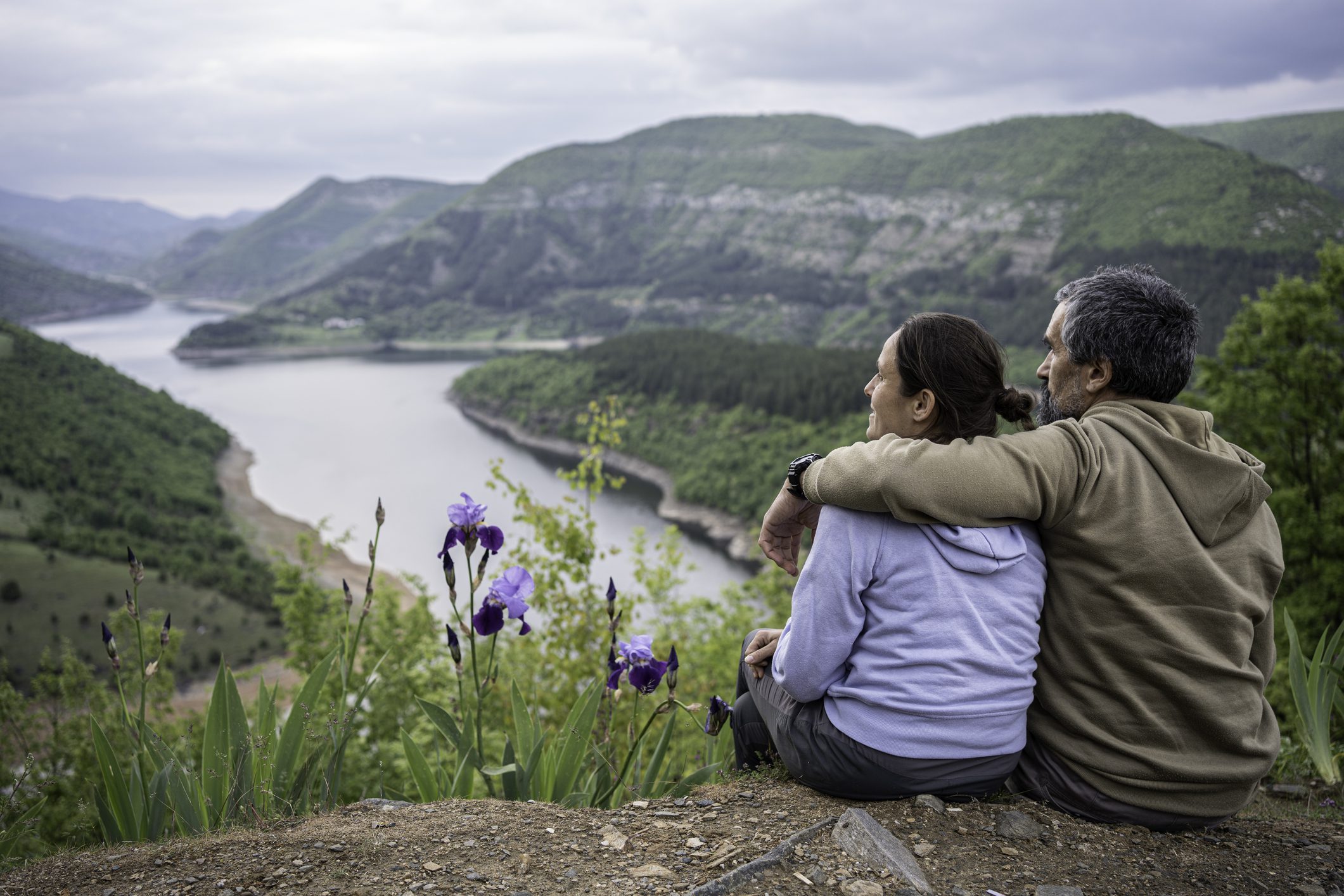 Pair sitting near river landscape