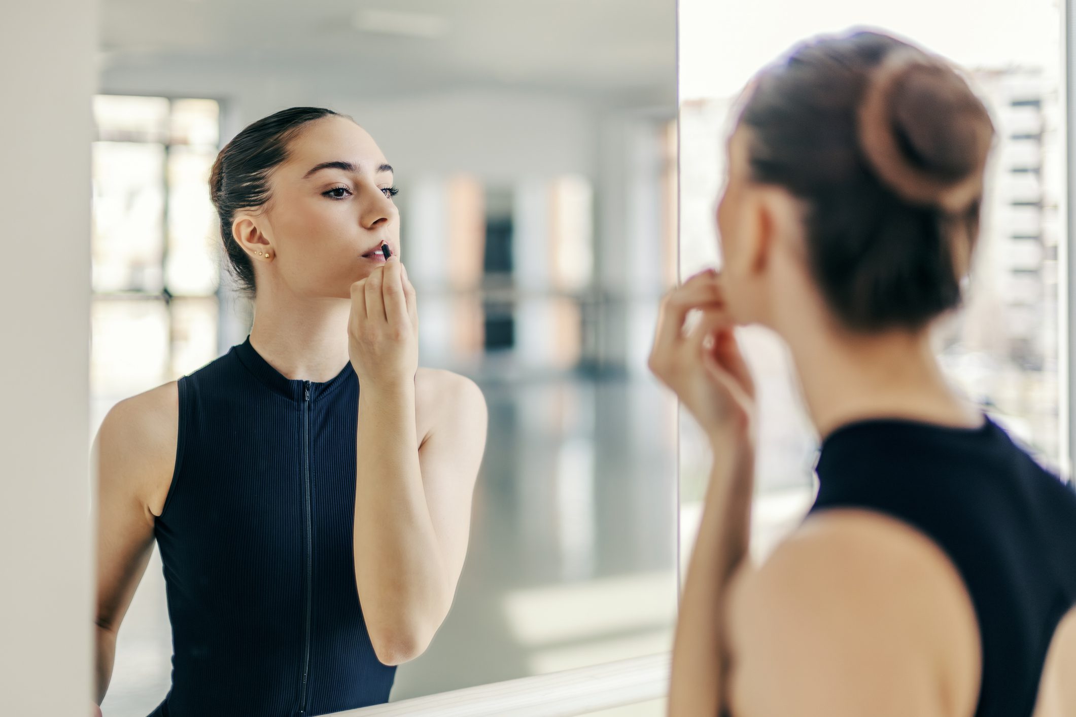 Ballet dancer doing makeup in mirror