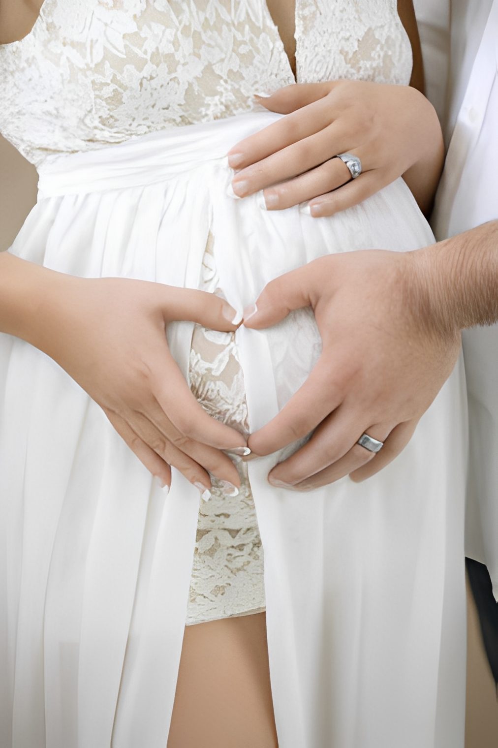 Hands creating heart shape on baby bump