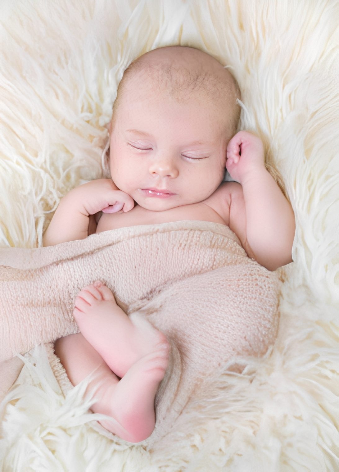 Peaceful infant on fluffy bedding