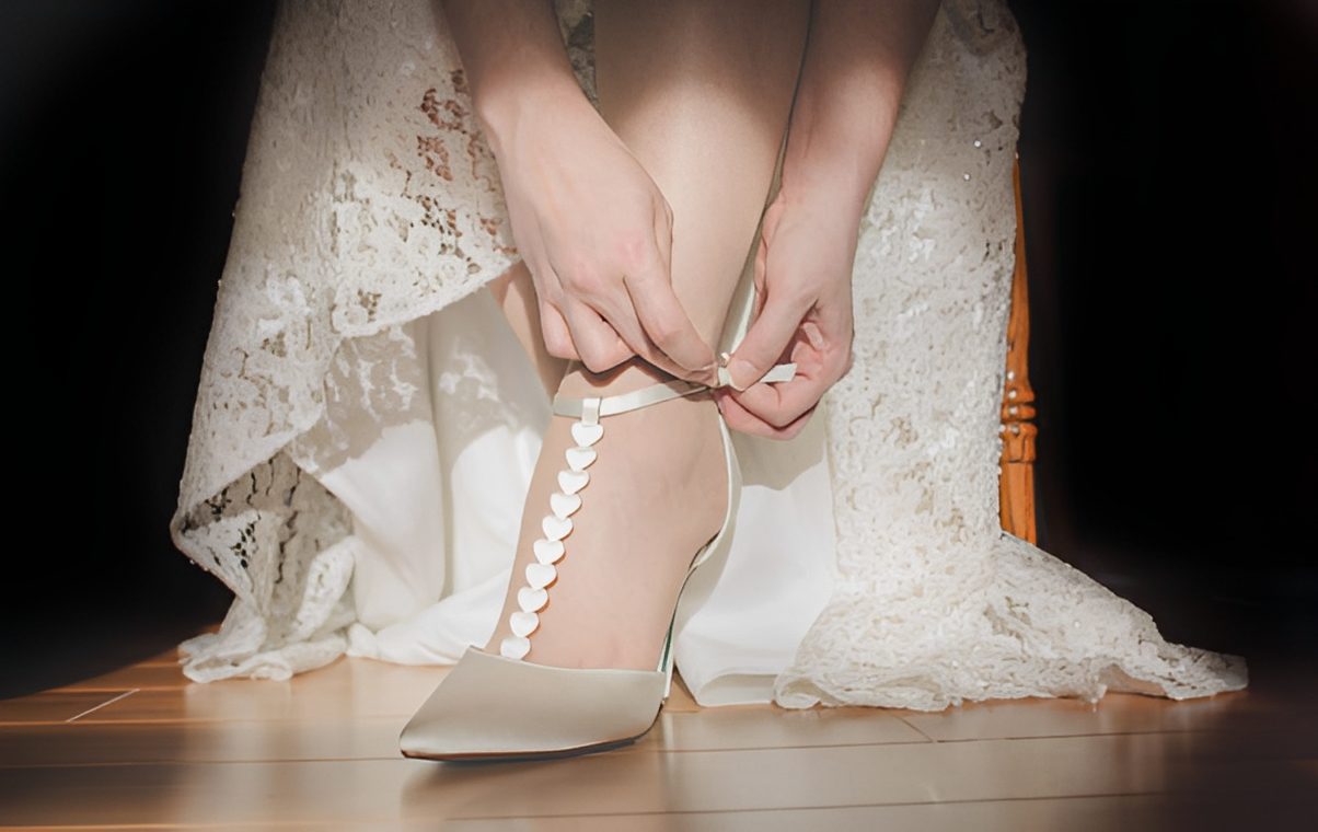 Bride adjusting elegant white shoe strap