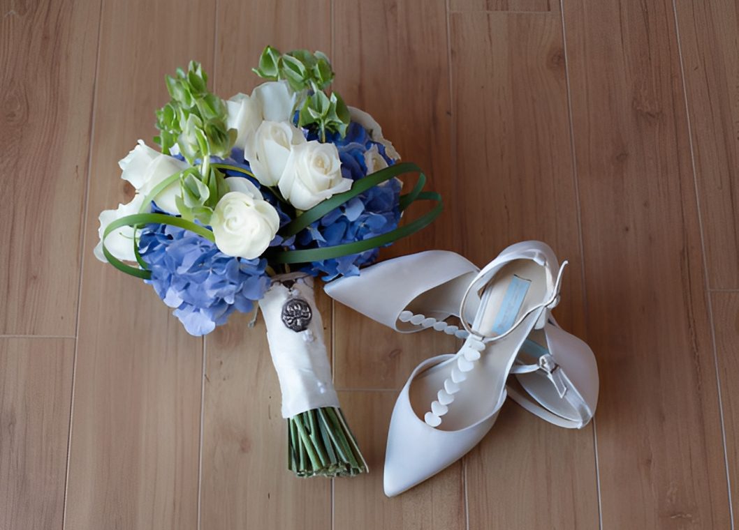 Wedding shoes beside floral arrangement